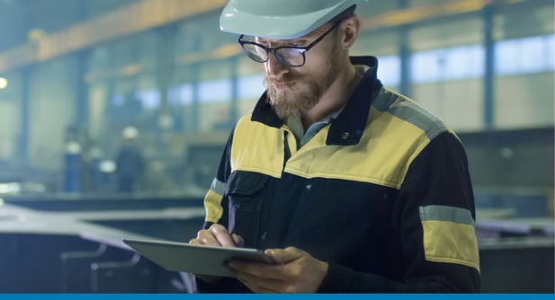 Employee in a manufacturing warehouse review bill of materials in SAP Business One on a tablet